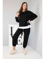 Dámska súprava s maslovou farbou, voľnou mikinou a teplákmi čiernej farby Dámska súprava s maslovou farbou, voľnou mikinou a teplákmi čiernej farby
