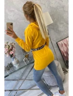 Šaty zdobené stuhou a nápismi v horčicovej farbe