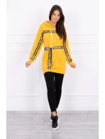 Šaty zdobené stuhou a nápismi v horčicovej farbe