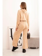 Dámska velúrová súprava so širokými nohavicami a mikinou s kapucňou béžová Dámska velúrová súprava so širokými nohavicami a mikinou s kapucňou béžová