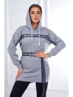 Šaty zdobené stuhou s nápisom šedá